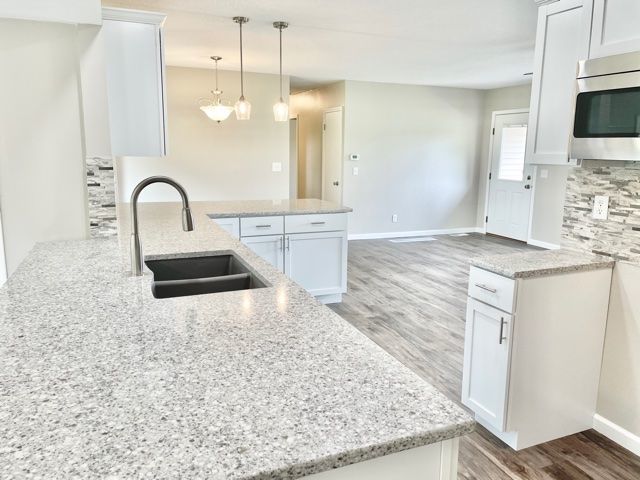 1028 Franklin Grove Road Dixon, IL 61021 - Photo 9 of 48 a kitchen with granite countertop a sink and a stove top oven