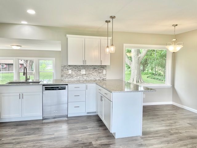 1028 Franklin Grove Road Dixon, IL 61021 - Photo 10 of 48 a kitchen with stainless steel appliances granite countertop a stove a sink and white cabinets with wooden floors