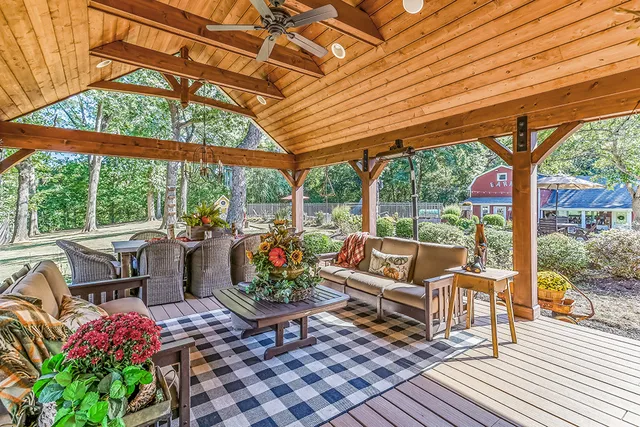 a view of a patio with table and chairs potted plants and large tree