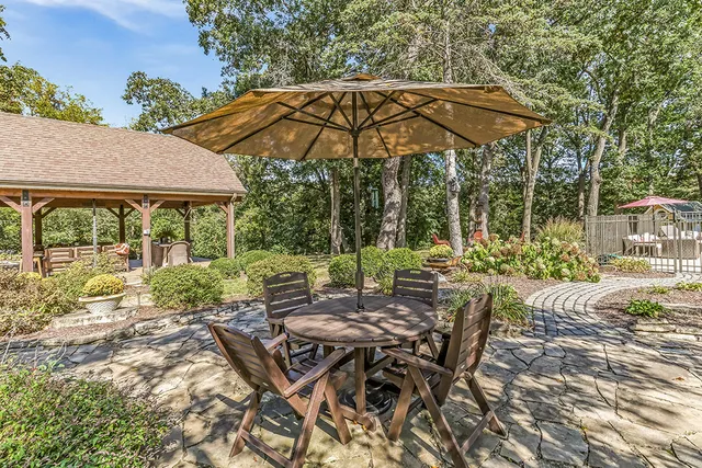 a view of a patio with a table and chairs next to a yard