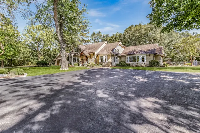 a front view of a house with a yard and trees