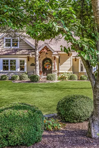 a front view of a house with a garden