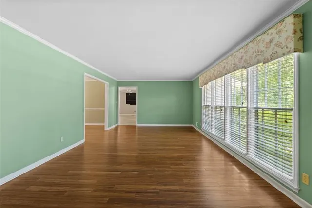 a view of a livingroom with wooden floor a fireplace and windows