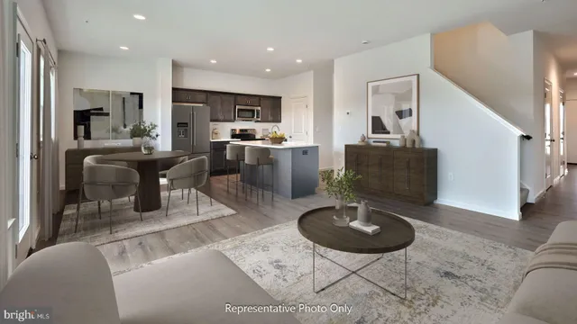 a living room with furniture a rug and kitchen view