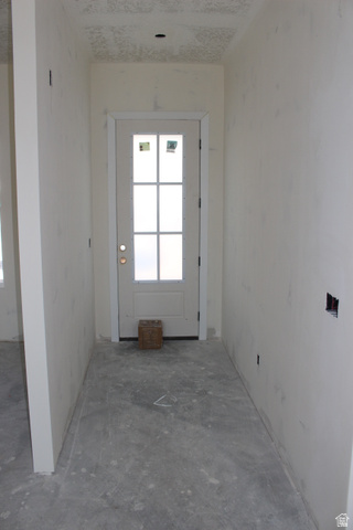 4933 East Remington Road Cedar City, UT 84721 - Photo 8 of 33 Entryway featuring a six-lite exterior door with a prominent sidelight, a textured ceiling, and concrete flooring
