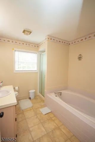 a spacious bathroom with a bathtub and a sink