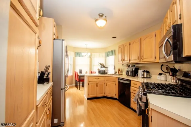a kitchen with stainless steel appliances a stove a sink dishwasher and cabinets with wooden floor