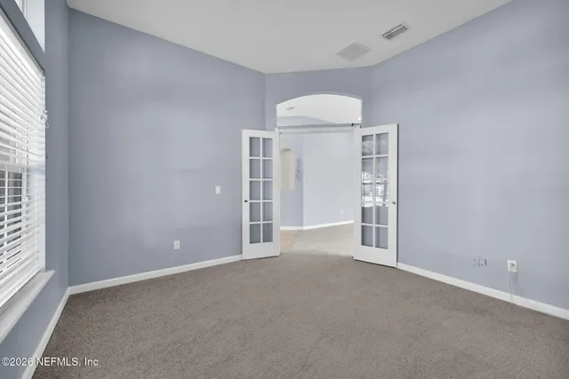 an empty room with closet and windows