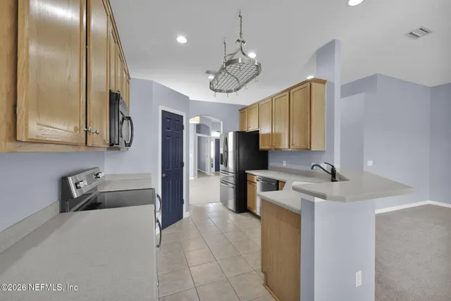 a kitchen with a refrigerator a sink dishwasher a oven with wooden cabinets and floor