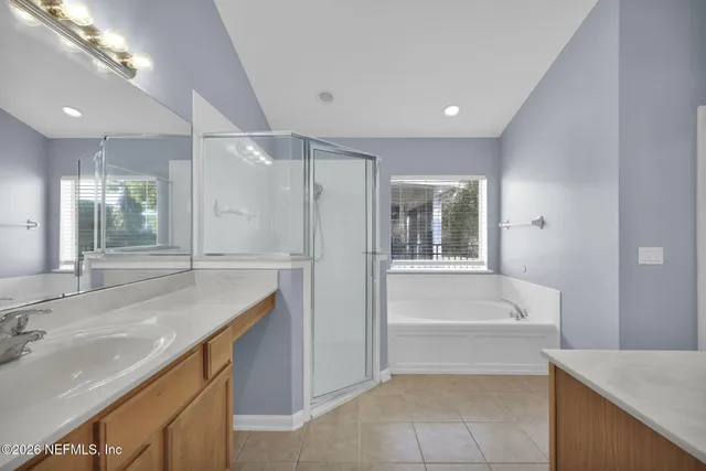 a bathroom with a granite countertop sink mirror and bathtub