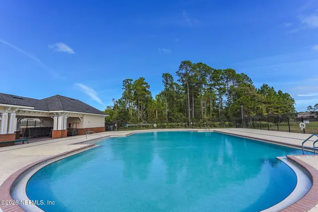 a view of a swimming pool with lawn chairs under an umbrella
