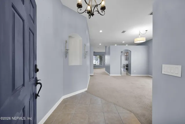 a view of a kitchen with a refrigerator and a chandelier