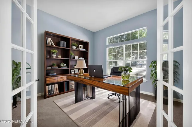 a view of a workspace with furniture and a window