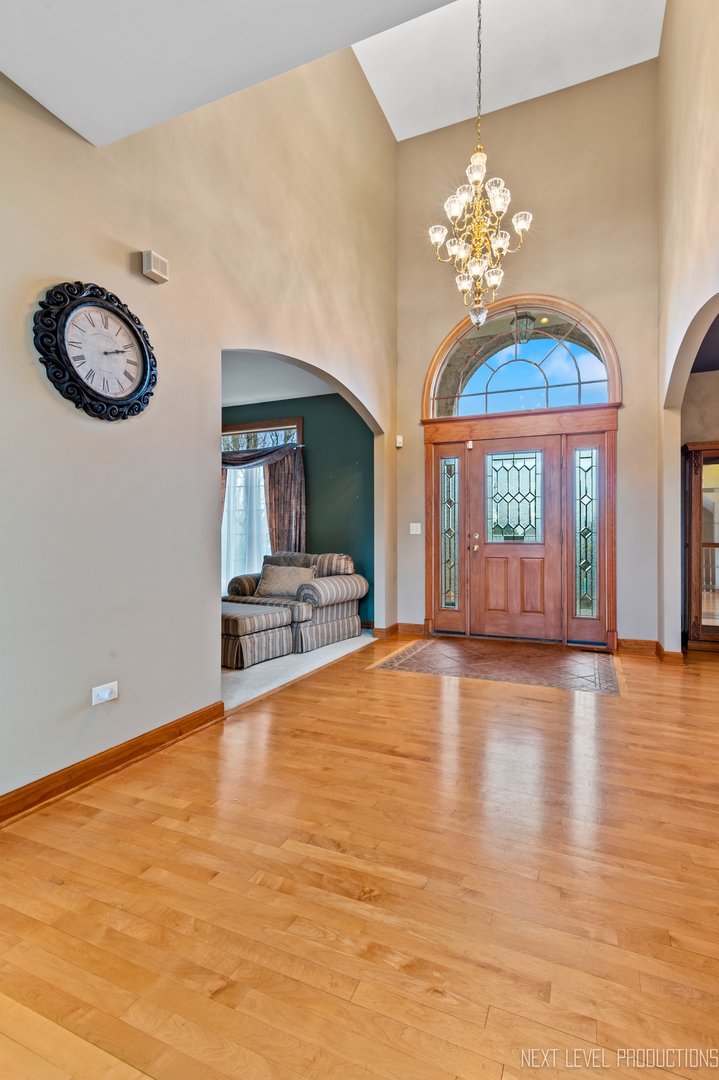 5370 Old Reserve Road Oswego, IL 60543 - Photo 13 of 48 a view of an empty room with a chandelier fan front door and windows