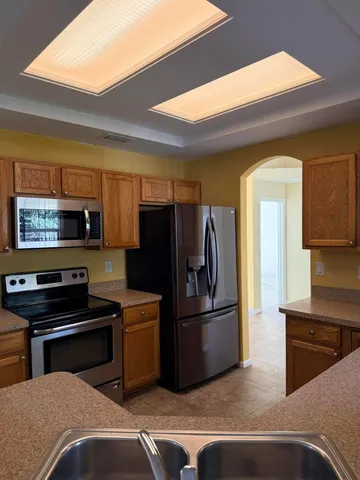a kitchen with stainless steel appliances a refrigerator and a stove top oven