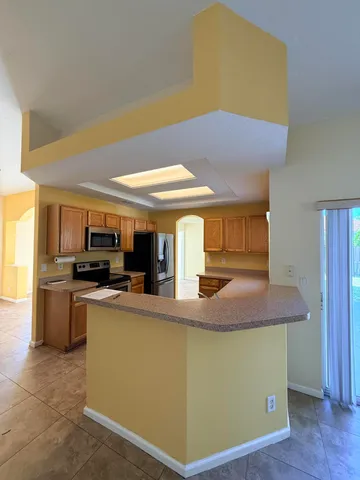 a kitchen with stainless steel appliances granite countertop a sink and a refrigerator