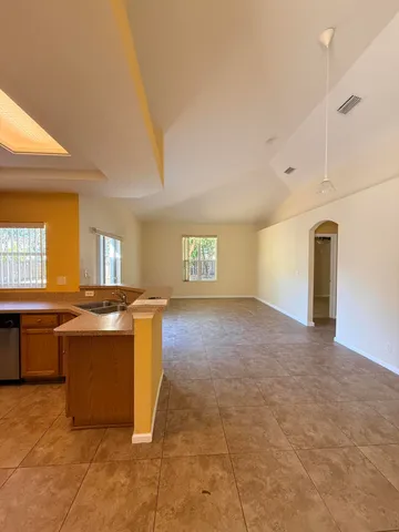 a view of a kitchen with a sink and dishwasher a oven with wooden floor