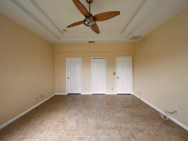 en empty room with ceiling fan and window