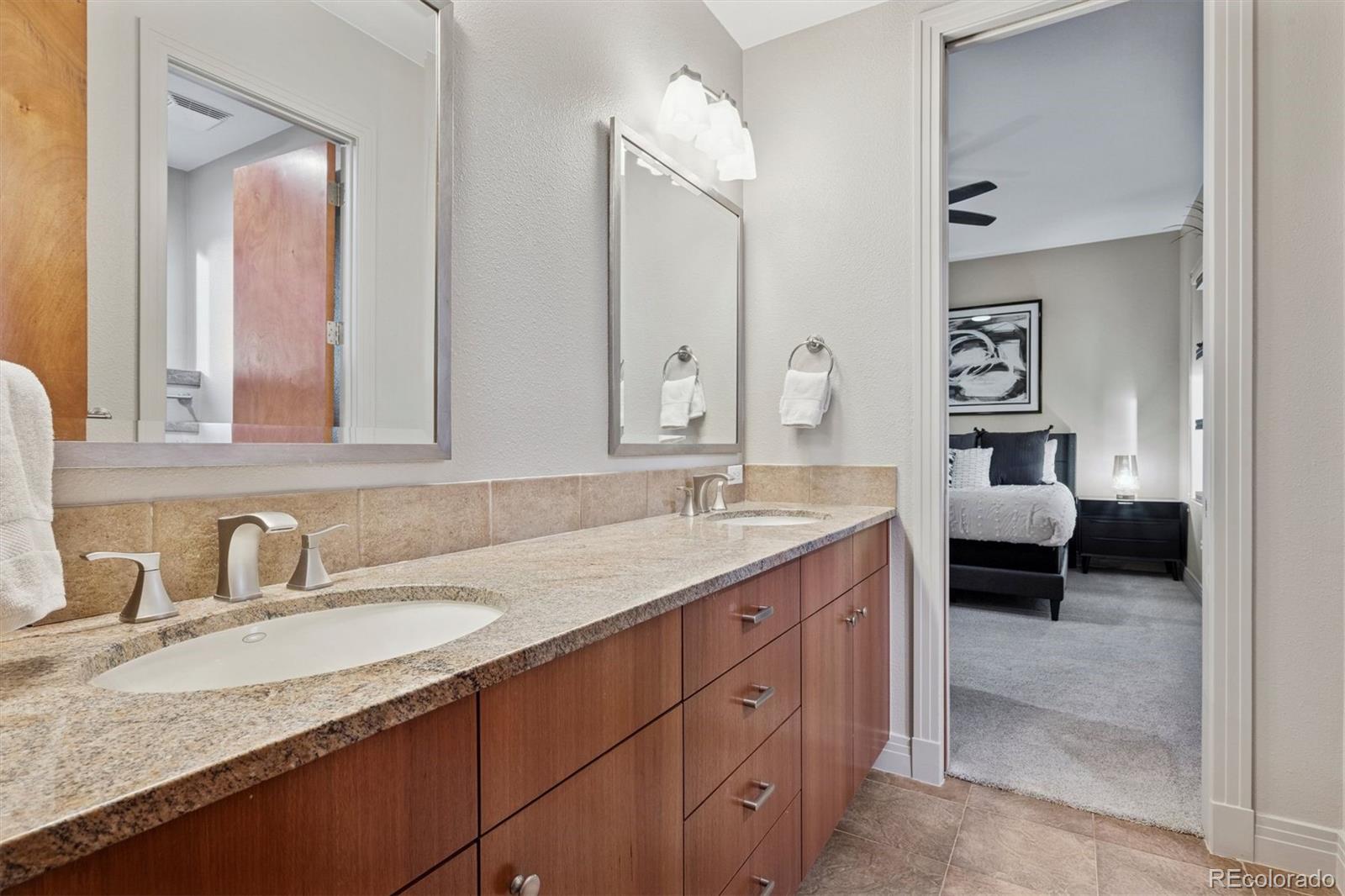 23534 Waynes Way Golden, CO 80401 - Photo 47 of 50 a en suite bathroom with a granite countertop sink and a mirror