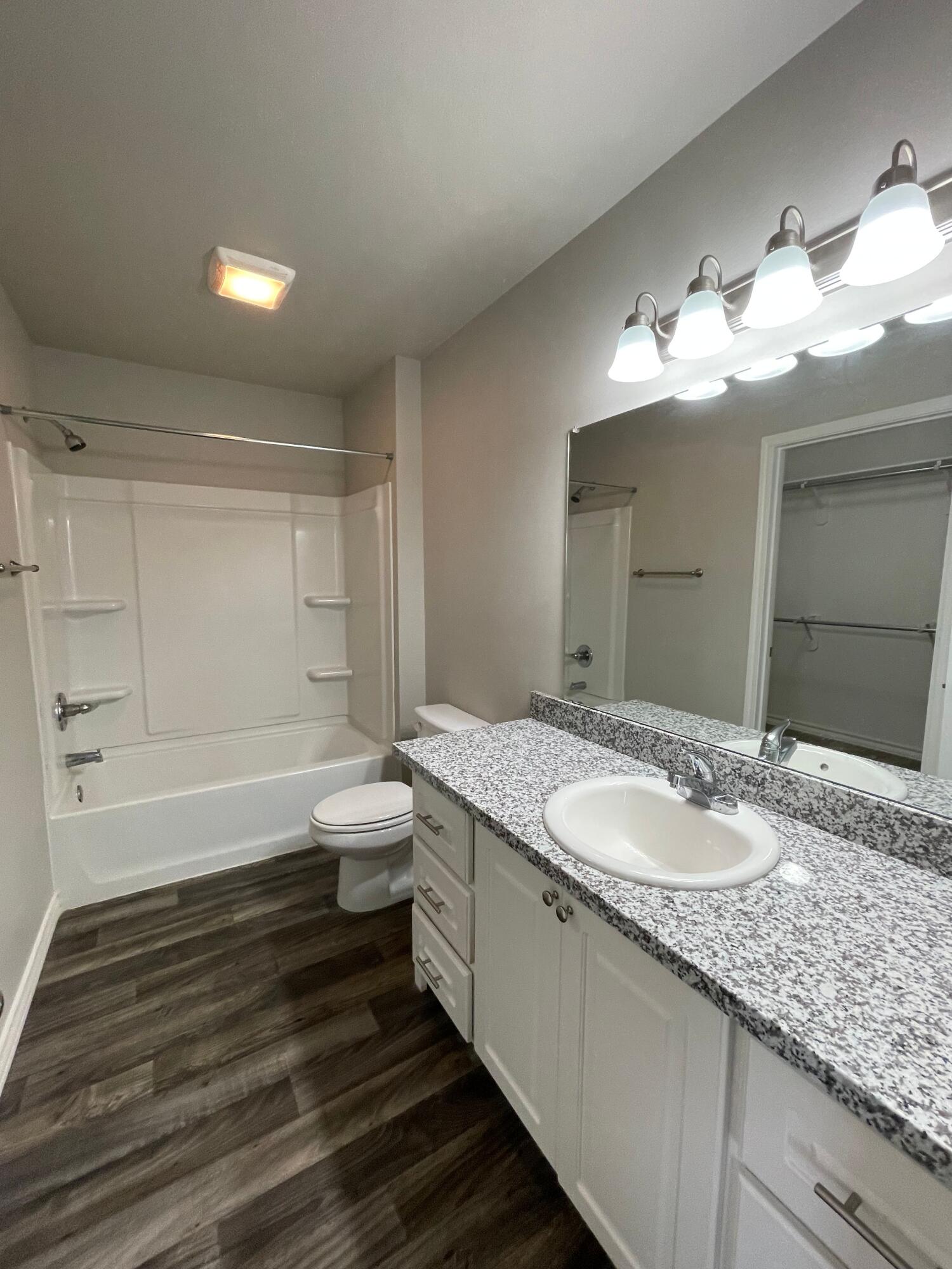 6040 24th Street, Unit 39 Lubbock, TX 79407 - Photo 8 of 13 a bathroom with a granite countertop sink a toilet and bathtub