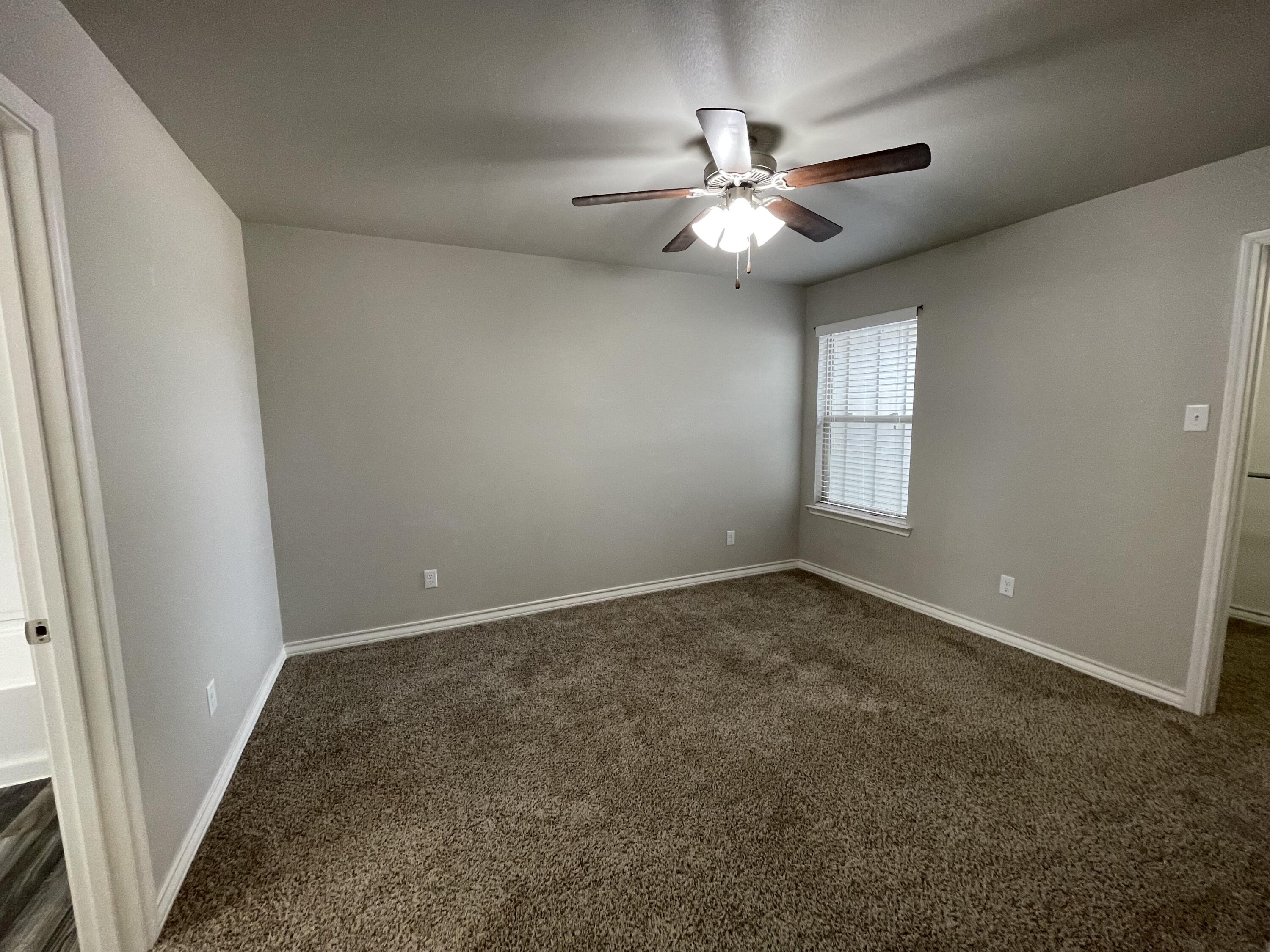6040 24th Street, Unit 39 Lubbock, TX 79407 - Photo 10 of 13 an empty room with windows and fan