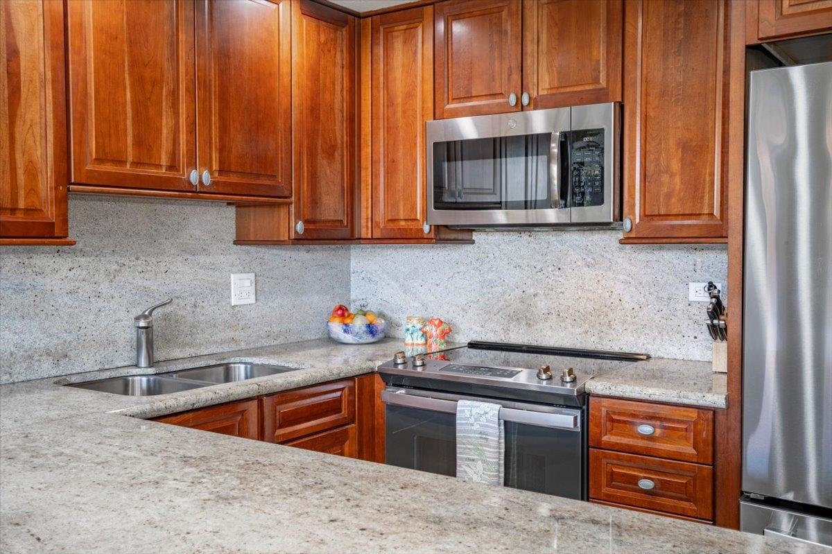 3543 Lower Honoapiilani Road, Unit J302 Lahaina, HI 96761 - Photo 17 of 44 a kitchen with stainless steel appliances granite countertop a sink stove and microwave