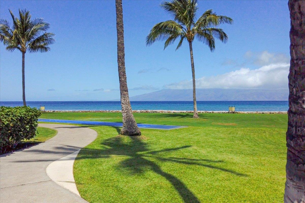 3543 Lower Honoapiilani Road, Unit J302 Lahaina, HI 96761 - Photo 29 of 44 a swimming pool with a yard and palm trees