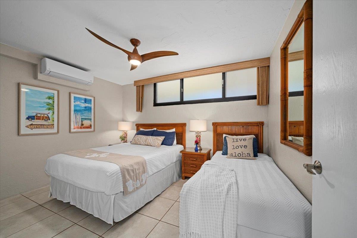 3543 Lower Honoapiilani Road, Unit J302 Lahaina, HI 96761 - Photo 31 of 44 a bedroom with a bed a ceiling fan and a window