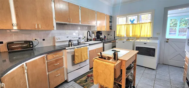 a kitchen with granite countertop a sink stove and cabinets