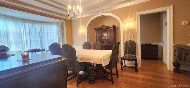 a dining room with furniture a chandelier and wooden floor