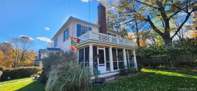 a view of a house with a yard and large tree and a yard