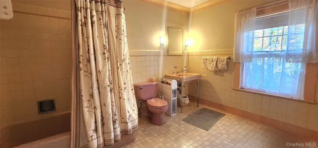 a bathroom with a sink a toilet and shower curtain