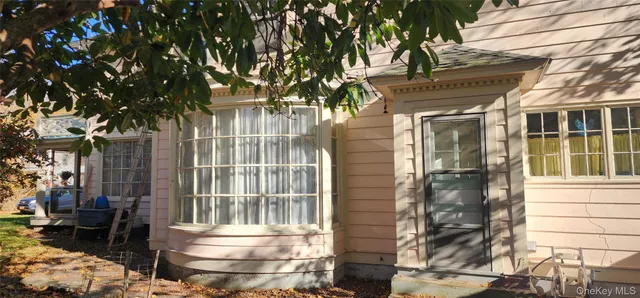 a front view of a house with a tree