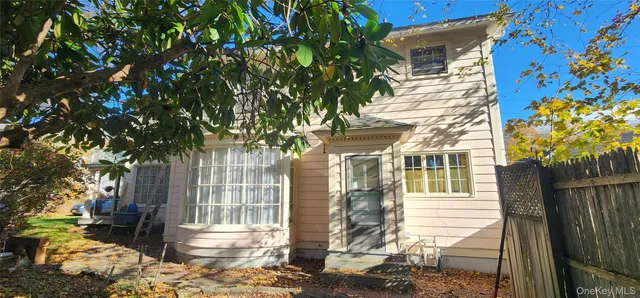a front view of a house with a tree