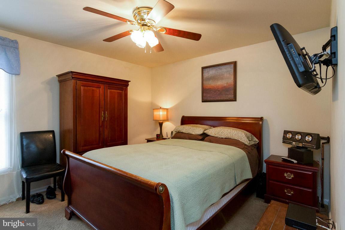 18310 Cattail Road Poolesville, MD 20837 - Photo 11 of 24 a bedroom with a bed and a chandelier