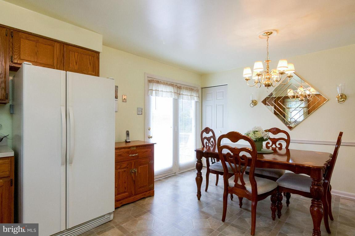 18310 Cattail Road Poolesville, MD 20837 - Photo 7 of 24 a dining room with furniture a chandelier and wooden floor
