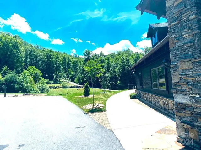 a view of a house with large trees in front of it