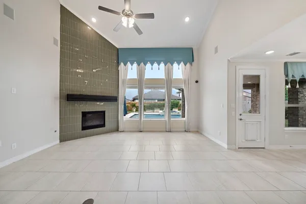 a living room with furniture a flat screen tv and a large window