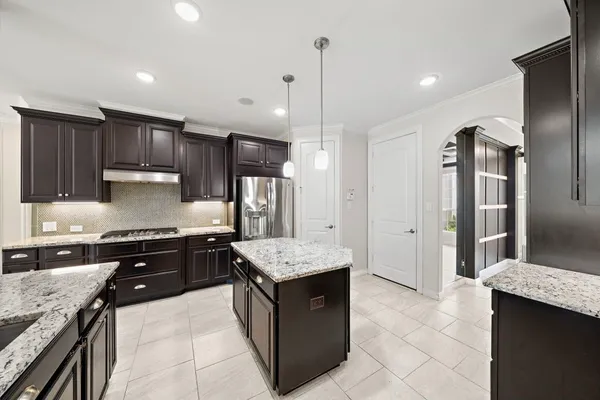 a large kitchen with stainless steel appliances kitchen island granite countertop a sink stove and refrigerator