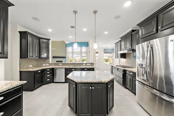 a large kitchen with kitchen island a sink stove and refrigerator