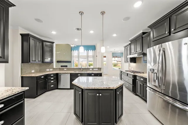 a large kitchen with kitchen island a sink stove and refrigerator