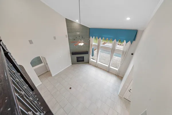 an empty room with windows and fan