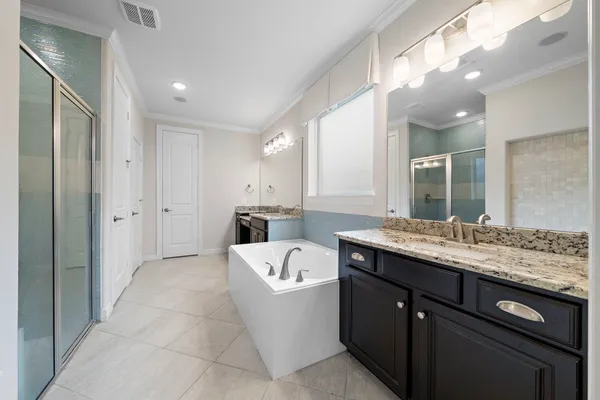 a en suite spacious bathroom with a granite countertop sink mirror and shower