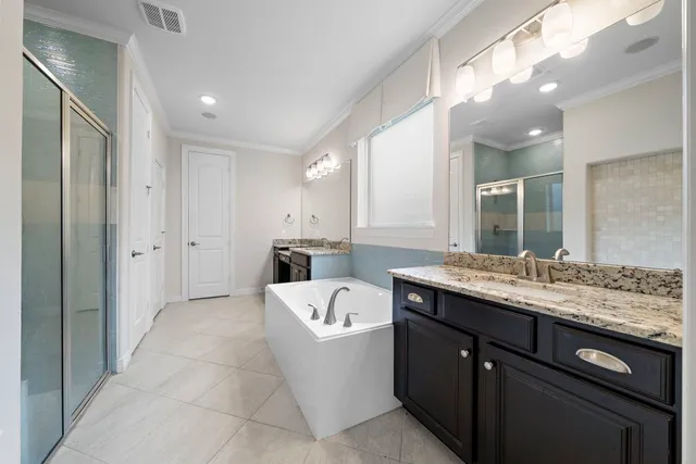 a en suite spacious bathroom with a granite countertop sink mirror and shower