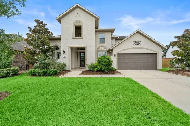 a view of white house with a yard and large tree