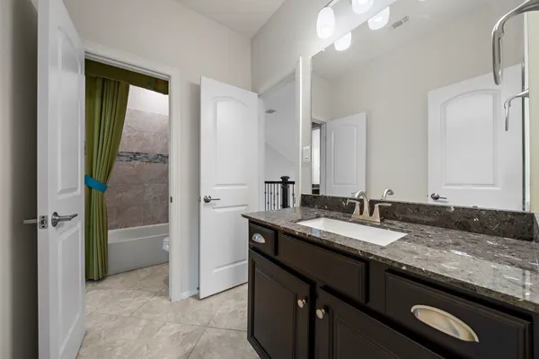 a bathroom with a granite countertop sink a toilet and a mirror
