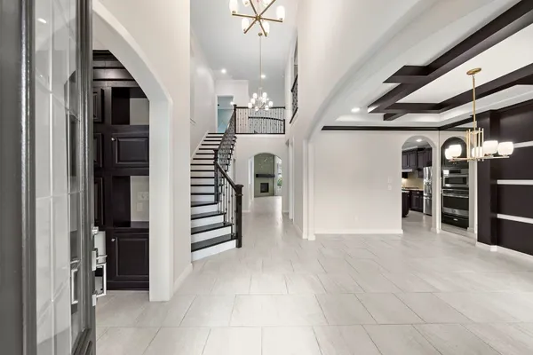 a view of a hallway with stairs and chandelier