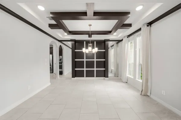 a view of an empty room with kitchen and a window
