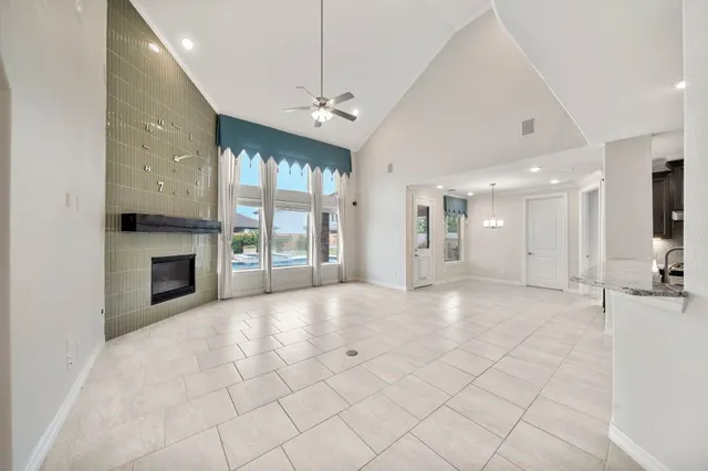 a view of an empty room with a fireplace and a window