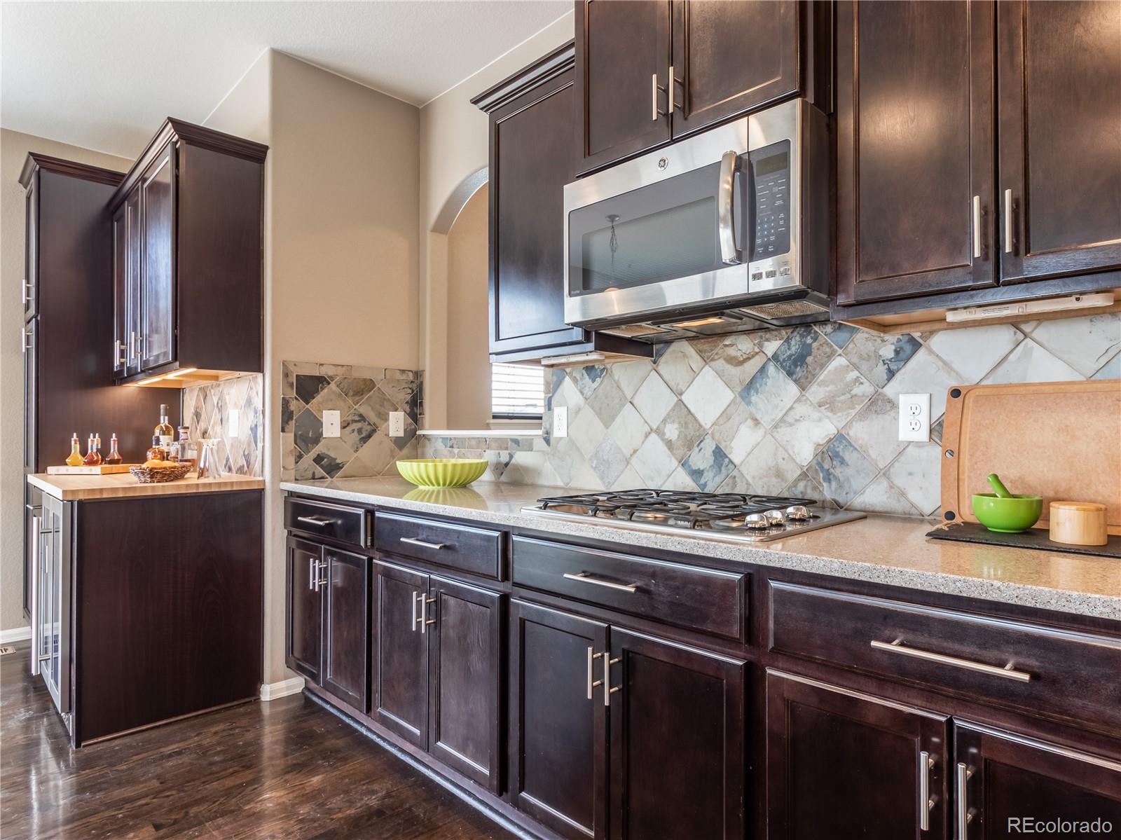 8639 Raspberry Drive Frederick, CO 80504 - Photo 12 of 30 a kitchen with stainless steel appliances granite countertop a sink stove and microwave
